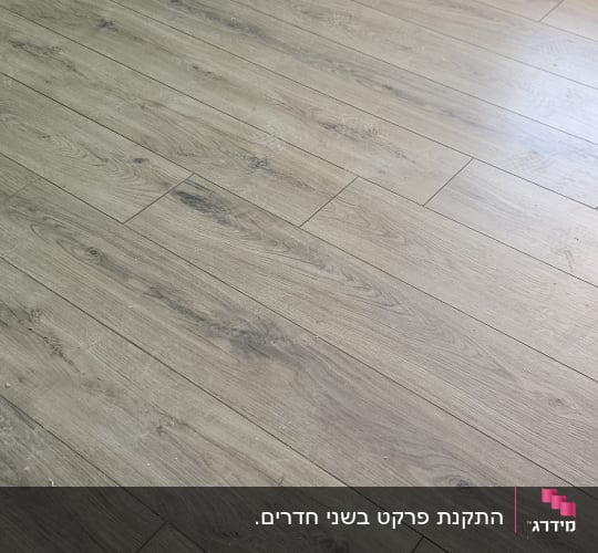 התקנת רצפת פרקט דמוי עץ בגוון בהיר עם פנלים לבנים